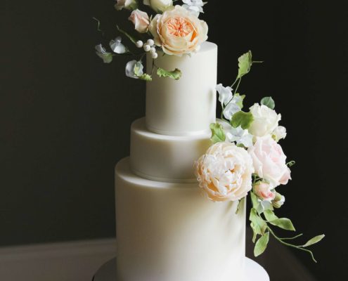 Off-white wedding cake with sugar flowers in pastel shades