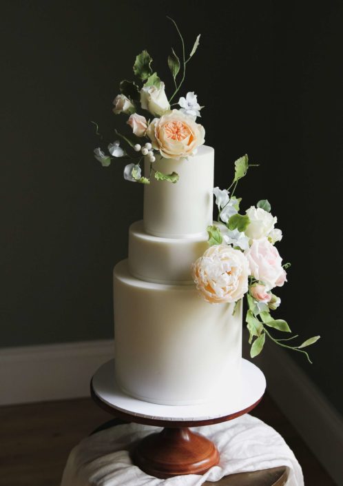 Off-white wedding cake with sugar flowers in pastel shades