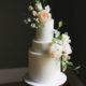 Off-white wedding cake with sugar flowers in pastel shades