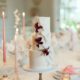 Blush wedding cake with fondant fabric texture and burgundy sugar flowers