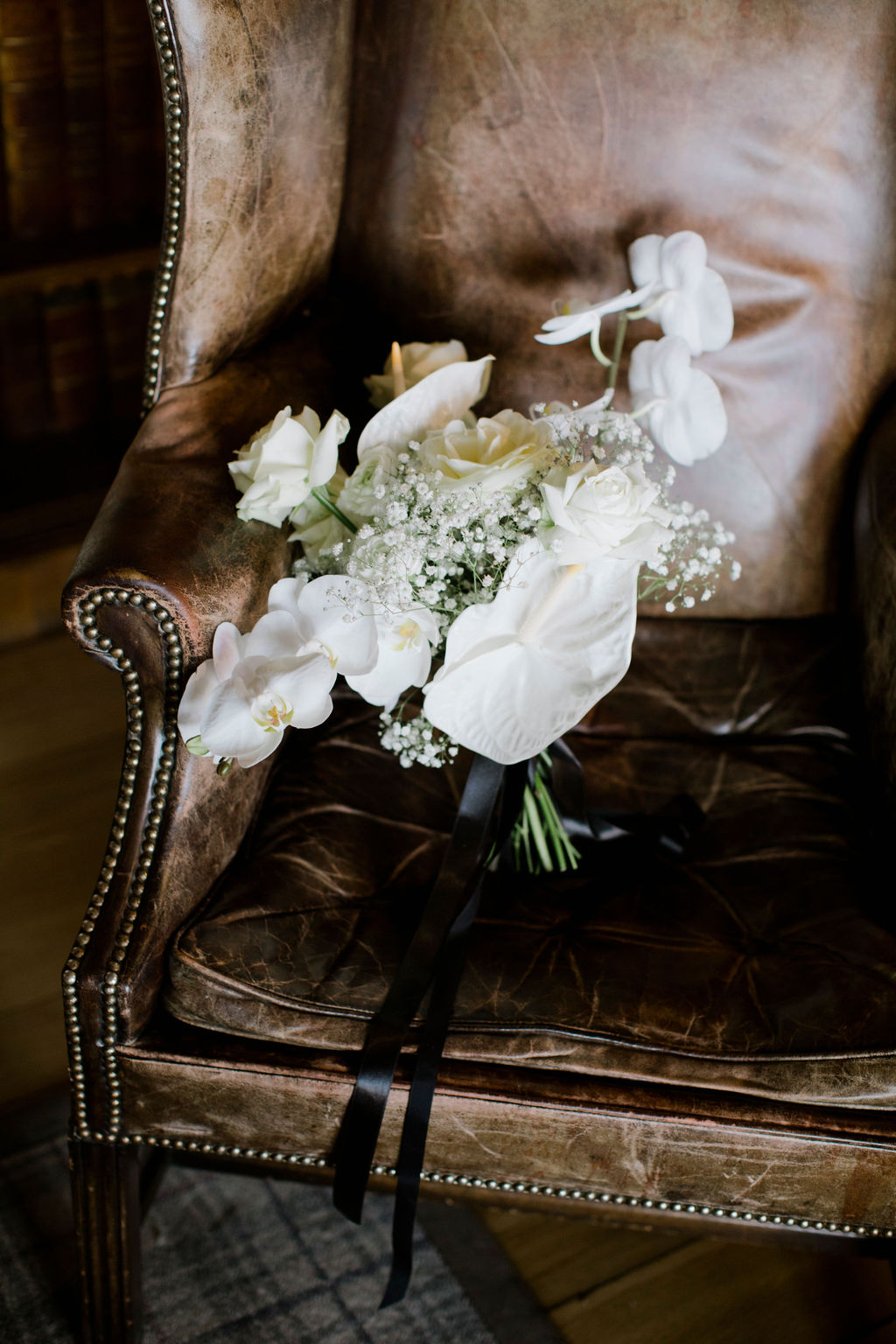 White wedding bouquet on brown leather chair