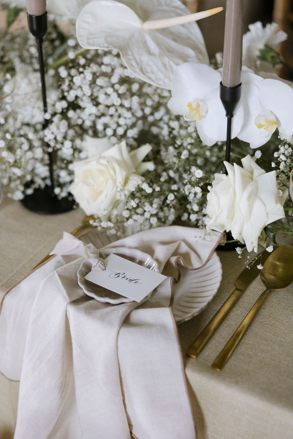 Wedding table place setting with white floral centrepieces