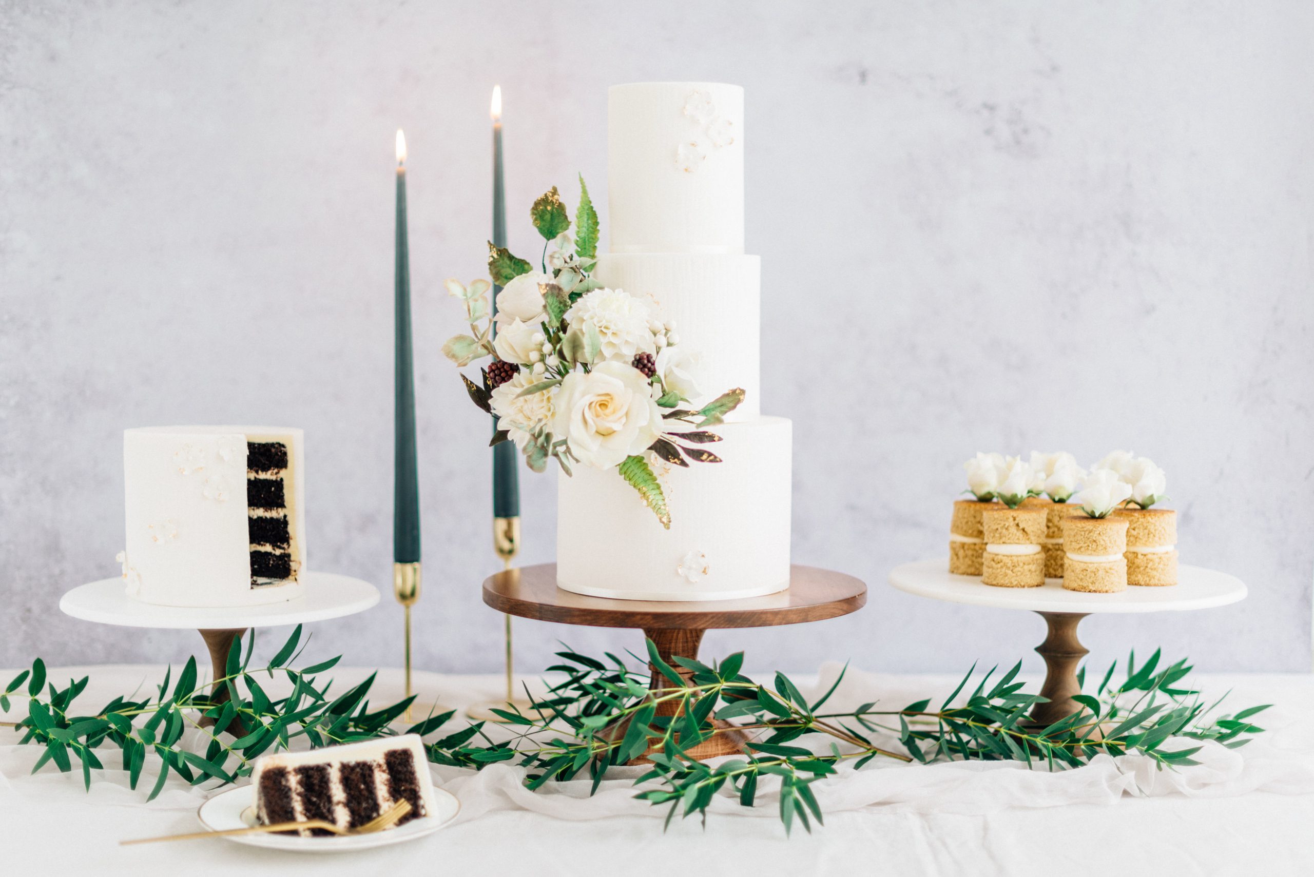 White wedding cake with sugar flowers, small chocolate cake and mini cakes