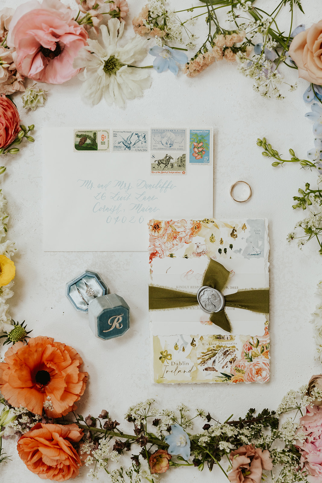 Floral wedding invitation in a flatlay with flowers surrounding