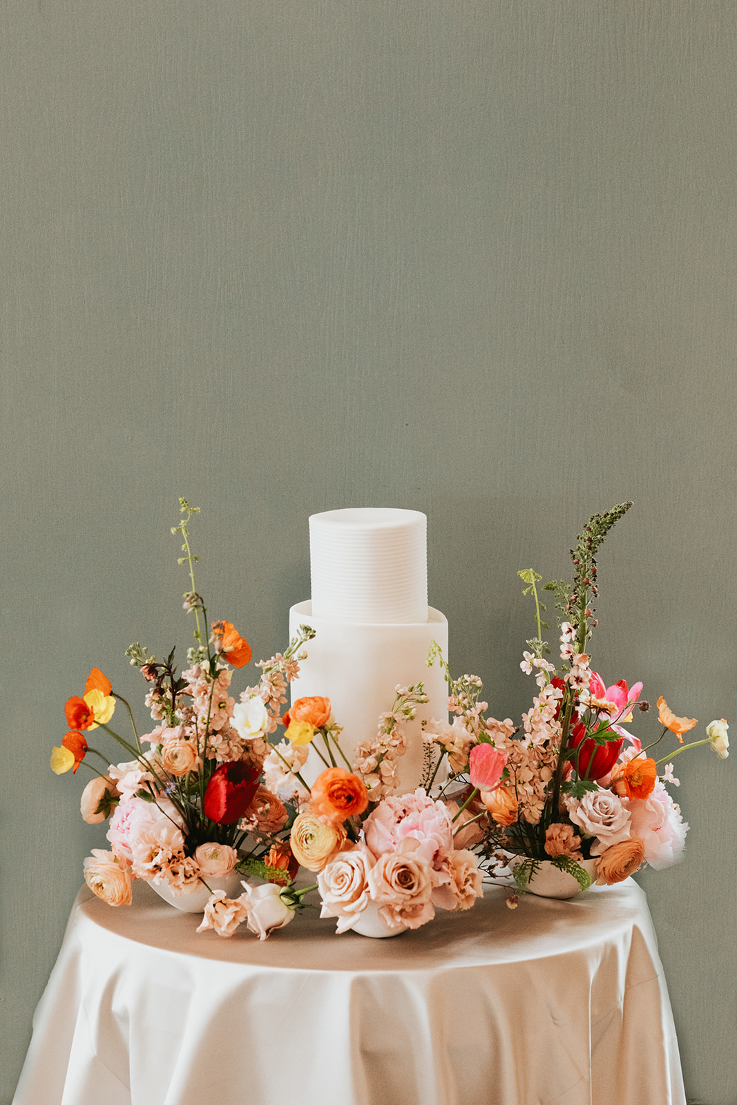 White wedding cake set up amongst spring flowers